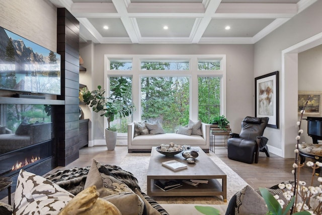 living room with a fireplace, beamed ceiling, coffered ceiling, and light wood-type flooring