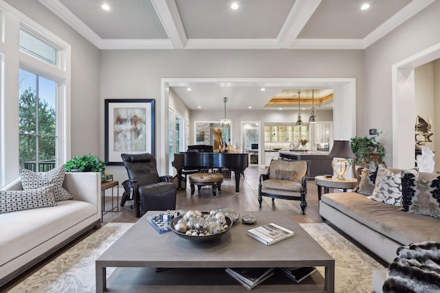 living room with beam ceiling, ornamental molding, a wealth of natural light, and light hardwood / wood-style flooring