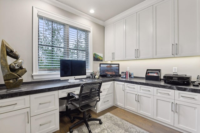 office featuring light hardwood / wood-style floors, built in desk, and ornamental molding