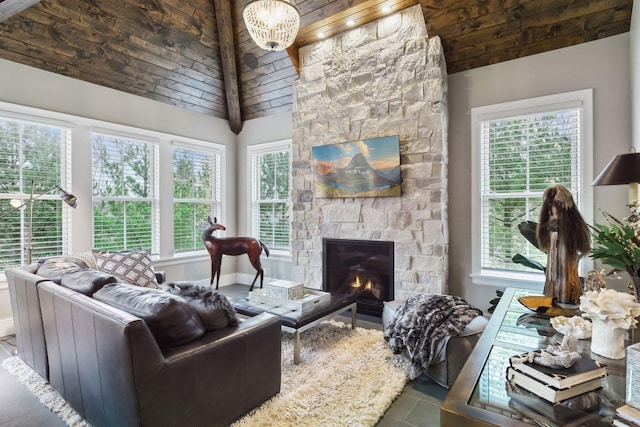 living room with a stone fireplace, a healthy amount of sunlight, and a notable chandelier