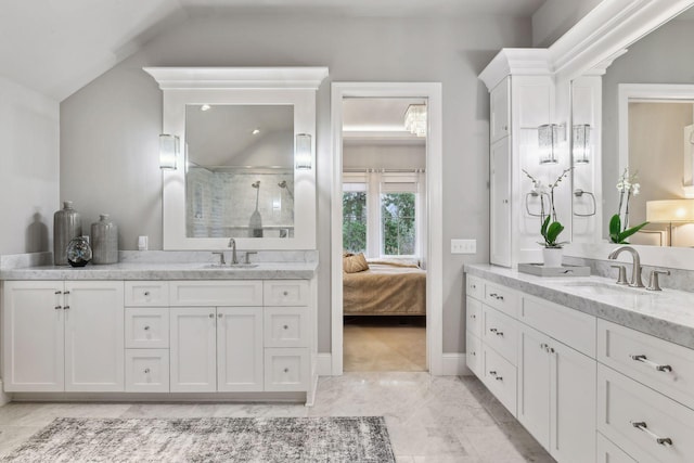 bathroom featuring tile patterned floors, vanity, lofted ceiling, and tiled shower