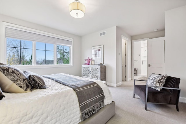 bedroom with light carpet and ensuite bathroom