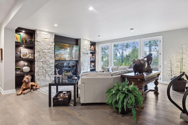 living room with wood-type flooring and built in shelves