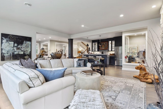 living room featuring hardwood / wood-style floors and ornate columns