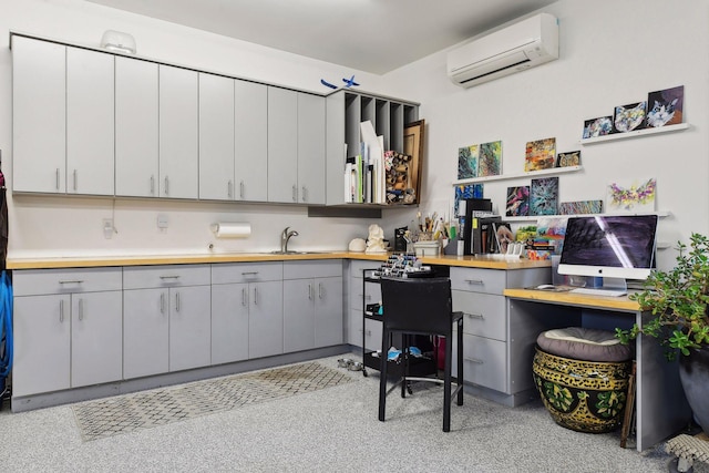 kitchen with gray cabinetry, wooden counters, sink, and a wall mounted AC