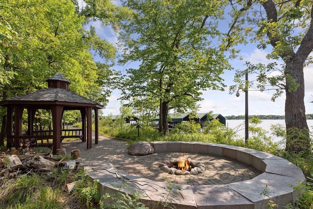 view of patio featuring a gazebo, a fire pit, and a water view