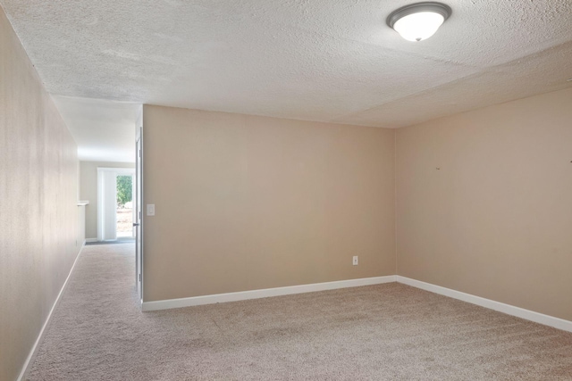 unfurnished room with light carpet and a textured ceiling