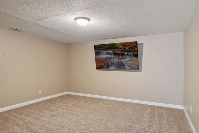 empty room with carpet floors and a textured ceiling