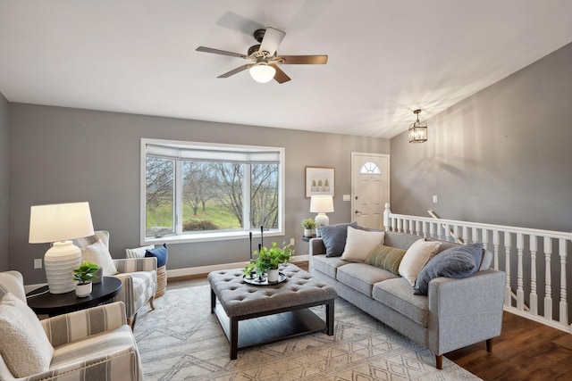 living room with wood-type flooring and ceiling fan with notable chandelier