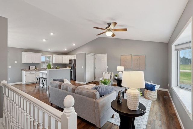 living room with dark hardwood / wood-style floors, ceiling fan, lofted ceiling, and a wealth of natural light