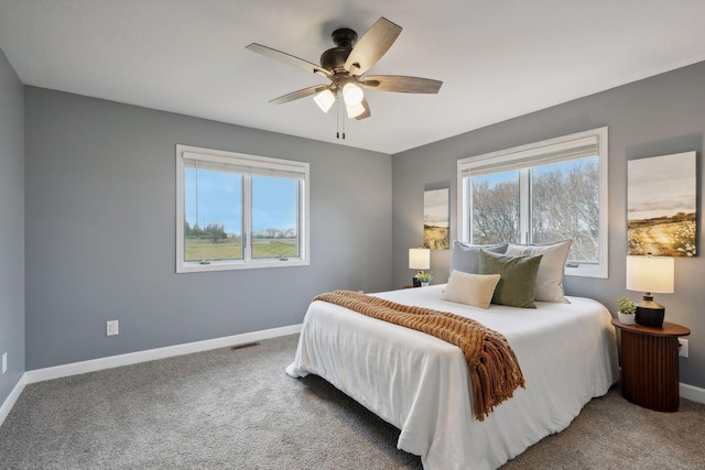 carpeted bedroom featuring multiple windows and ceiling fan