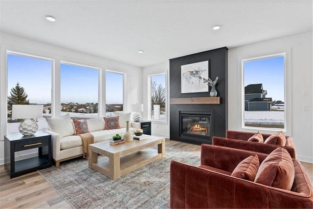 living room featuring light wood-type flooring and a large fireplace