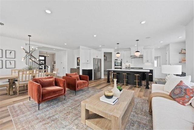 living room with a chandelier and light hardwood / wood-style floors