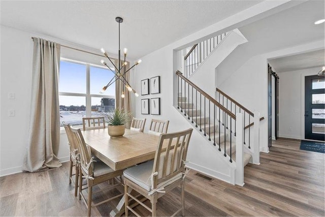 dining space with hardwood / wood-style flooring and a chandelier