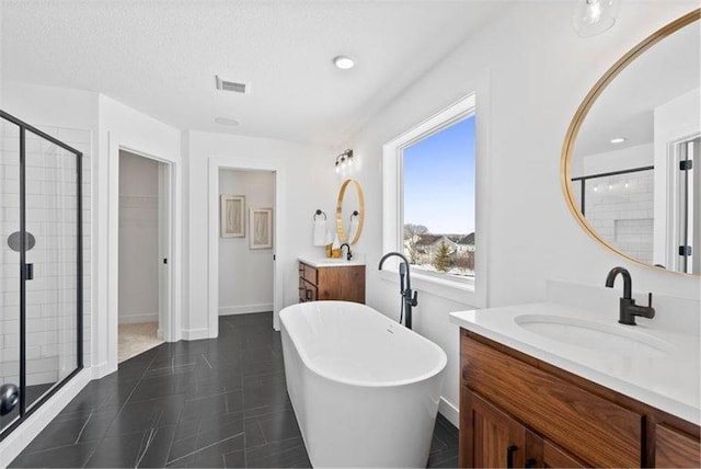 bathroom with independent shower and bath, vanity, and a textured ceiling