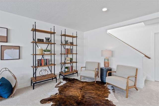 living area featuring a textured ceiling and carpet floors