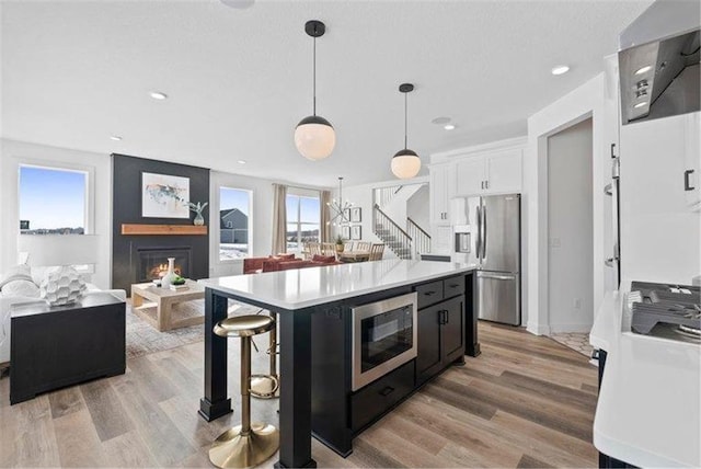 4098 Gable Ln, Woodbury, MN 55129 - kitchen featuring stainless steel fridge, built in microwave, open floor plan, and light countertops