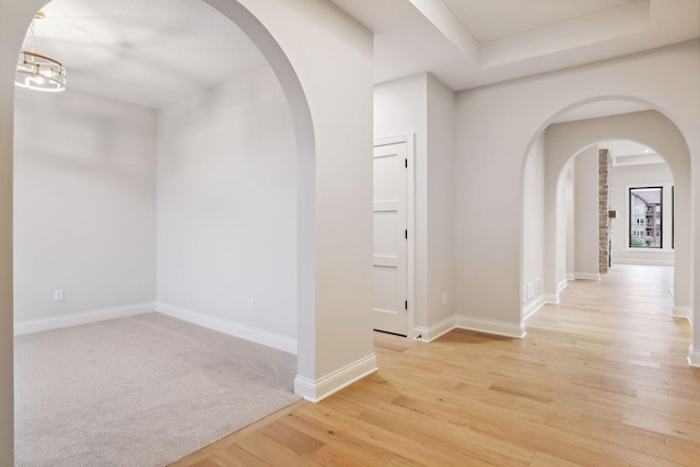 corridor with a chandelier and wood-type flooring