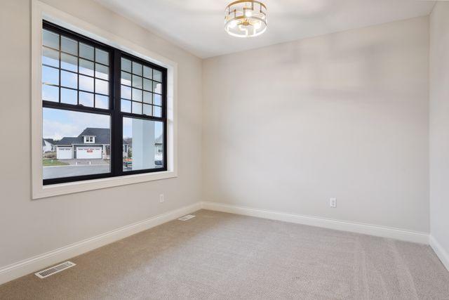 empty room featuring a chandelier and carpet floors