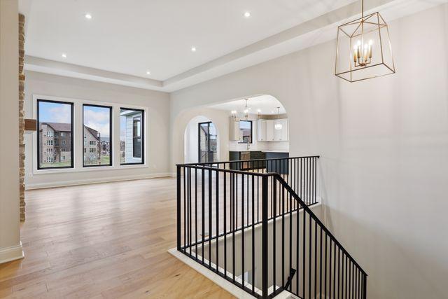 corridor with a chandelier and light hardwood / wood-style floors