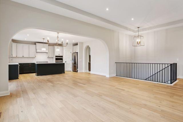 unfurnished living room with light wood-type flooring and sink