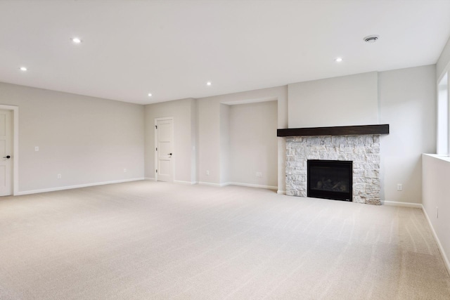 unfurnished living room featuring a fireplace and light colored carpet