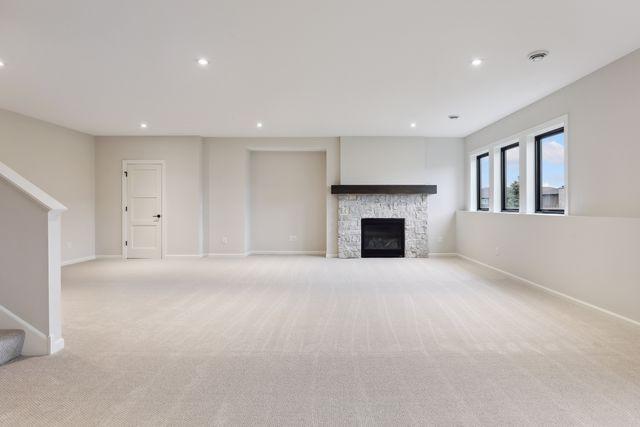 unfurnished living room with a fireplace and light carpet