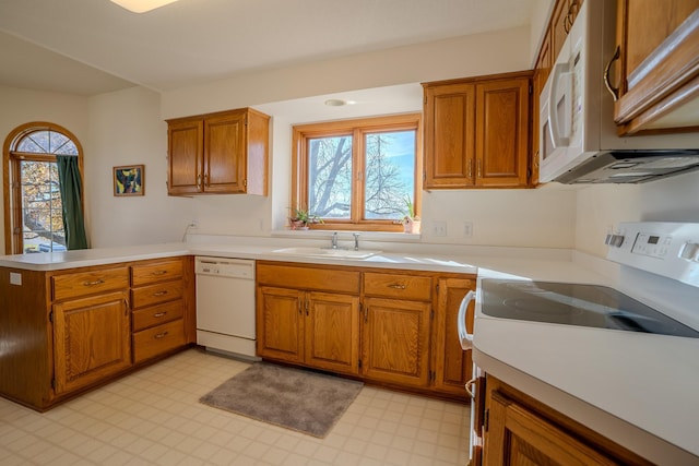 kitchen with kitchen peninsula, white appliances, and sink