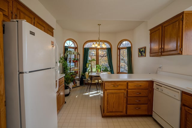 kitchen with decorative light fixtures, white appliances, kitchen peninsula, and a chandelier