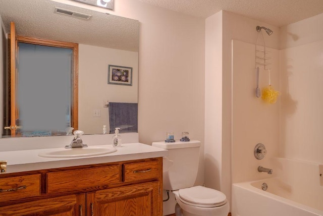 full bathroom with vanity, tub / shower combination, toilet, and a textured ceiling