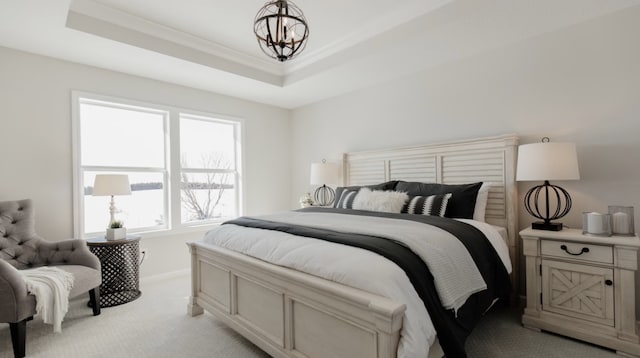 carpeted bedroom featuring ornamental molding, a raised ceiling, and a notable chandelier