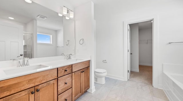 full bath with a walk in closet, visible vents, a sink, and double vanity