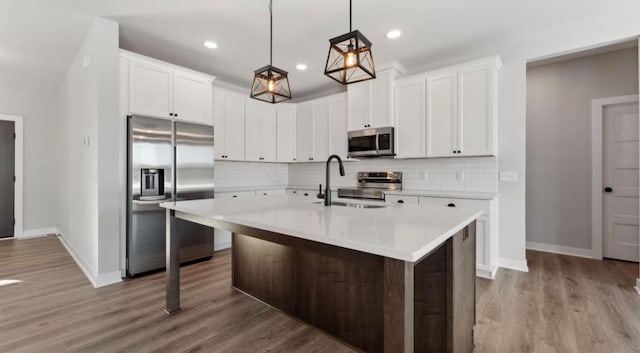 kitchen featuring stainless steel appliances, a sink, light countertops, and decorative backsplash