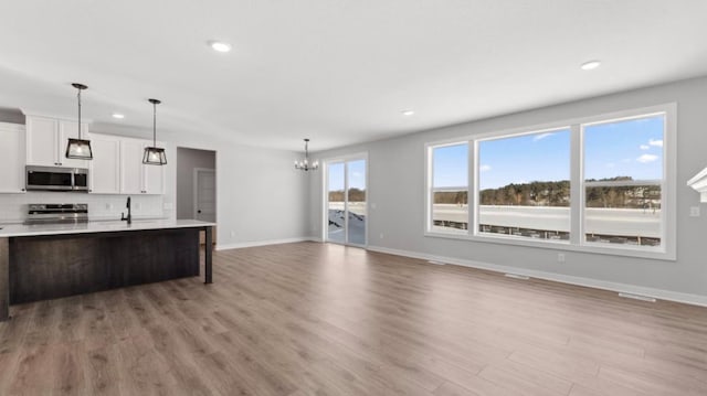 kitchen with a healthy amount of sunlight, decorative backsplash, stainless steel appliances, and light countertops