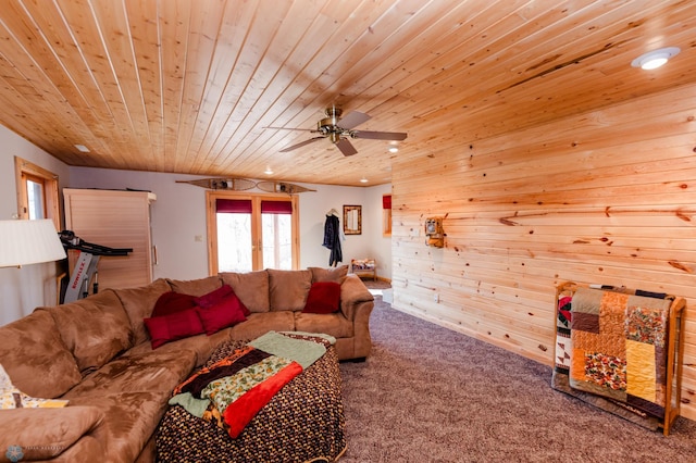 living room featuring wooden ceiling, ceiling fan, wooden walls, and carpet flooring