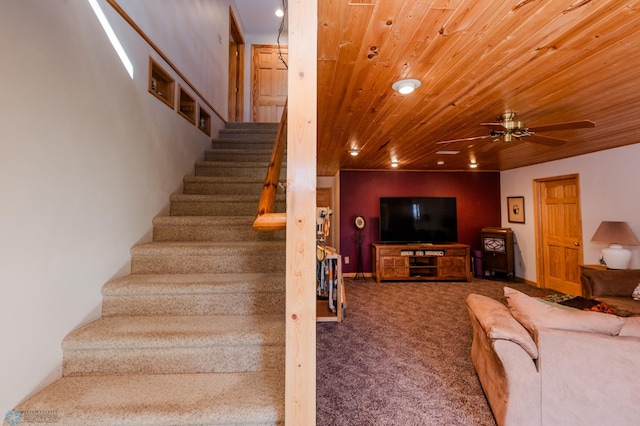 staircase with carpet flooring, ceiling fan, and wood ceiling