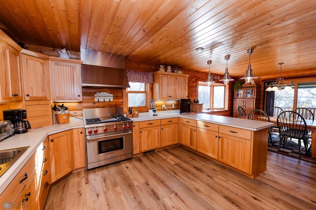 kitchen with kitchen peninsula, plenty of natural light, custom exhaust hood, hanging light fixtures, and luxury stove