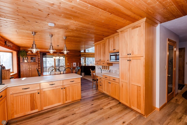 kitchen with pendant lighting, stainless steel microwave, wooden ceiling, and light hardwood / wood-style floors