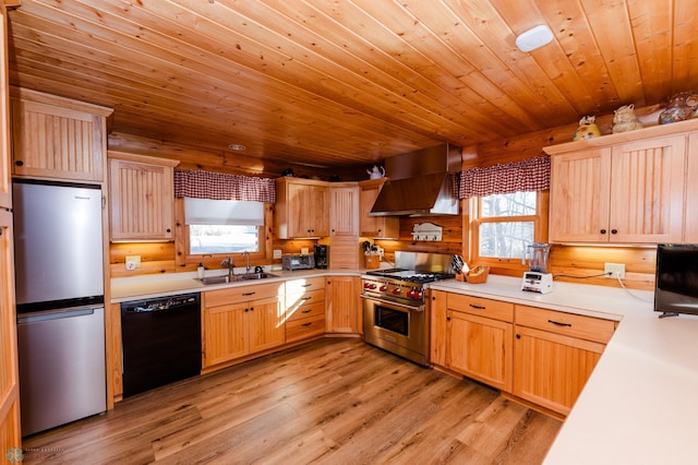 kitchen with stainless steel appliances, a wealth of natural light, wall chimney range hood, and light wood-type flooring