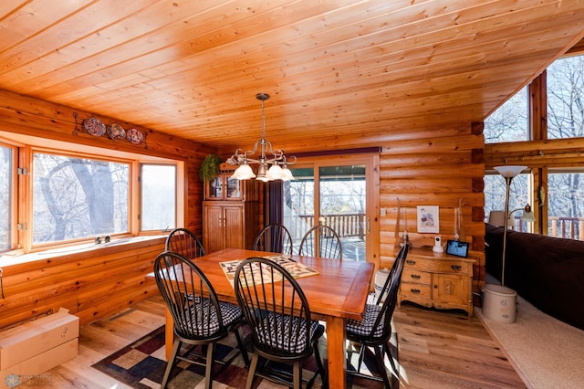 dining space with wooden ceiling, light hardwood / wood-style floors, a healthy amount of sunlight, and an inviting chandelier