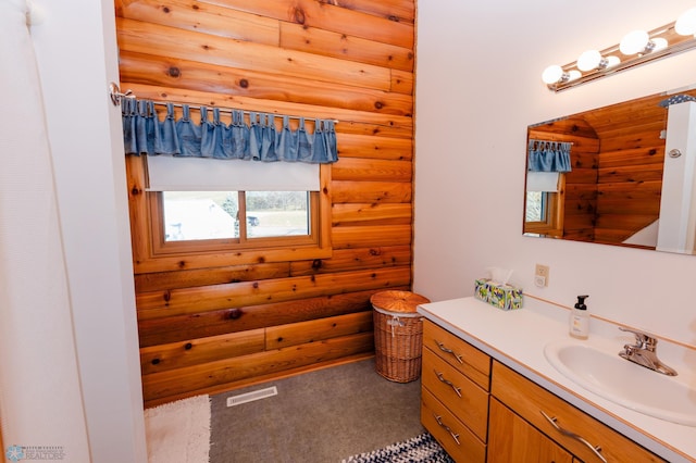 bathroom featuring vanity and rustic walls