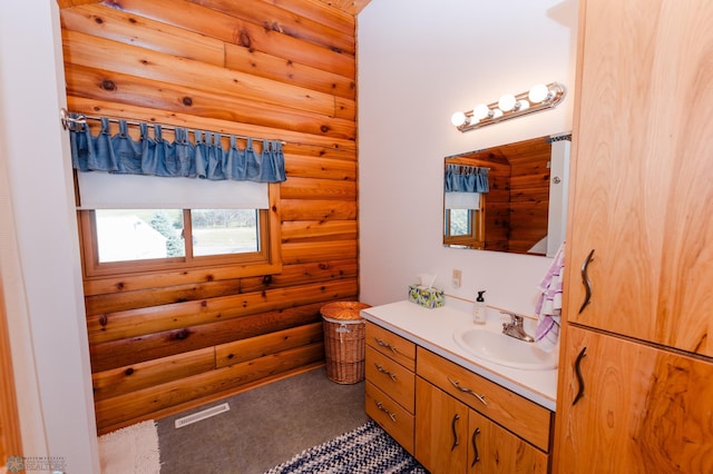 bathroom featuring vanity and log walls