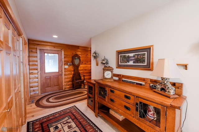 entryway with light hardwood / wood-style floors and log walls