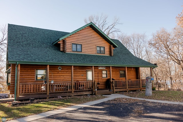 log home featuring covered porch