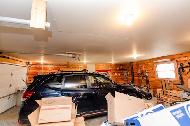 garage with a garage door opener and wood walls