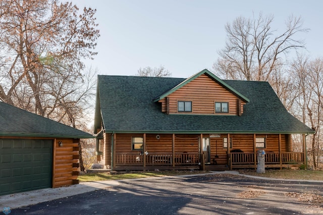 log-style house with a garage and a porch