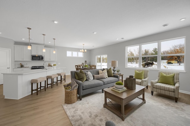 living room featuring an inviting chandelier and light hardwood / wood-style flooring