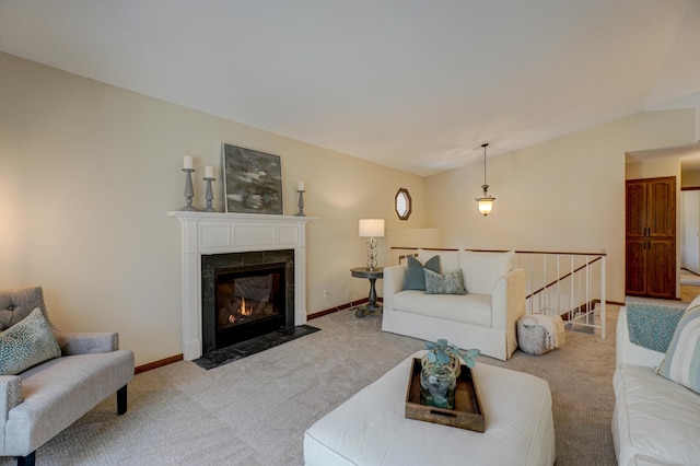 living room featuring a tiled fireplace, vaulted ceiling, and light carpet