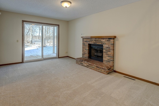 unfurnished living room featuring light colored carpet, a brick fireplace, and a textured ceiling