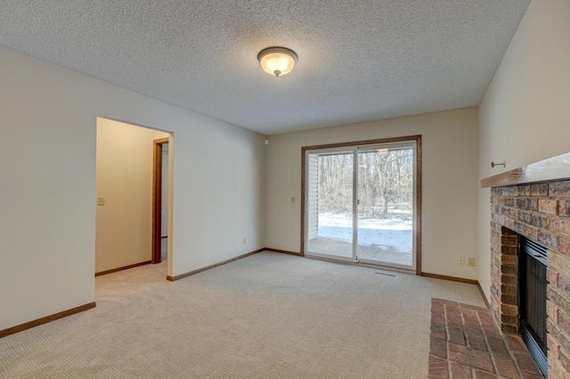 unfurnished living room featuring a brick fireplace, light carpet, and a textured ceiling